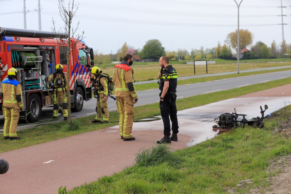 Snorscooter langs de weg uitgebrand