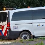 Politiebusje vast in de berm