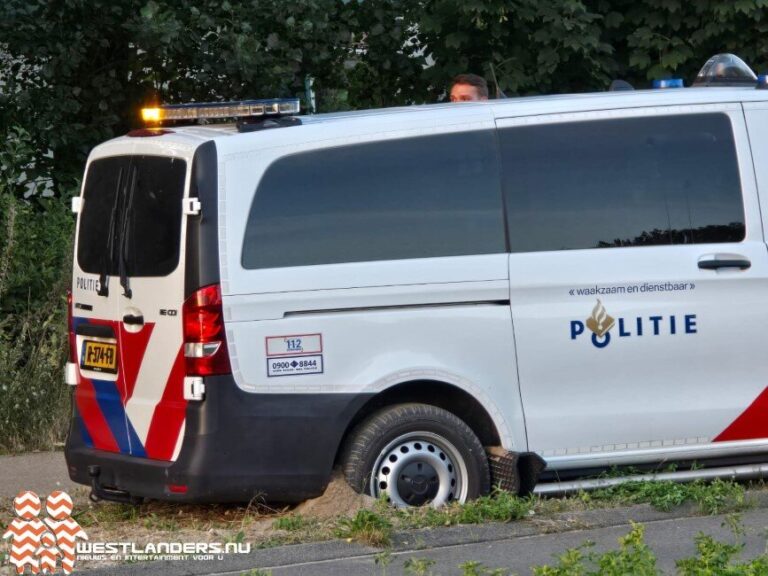 Politiebusje vast in de berm