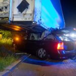 Auto klem onder vrachtwagentrailer