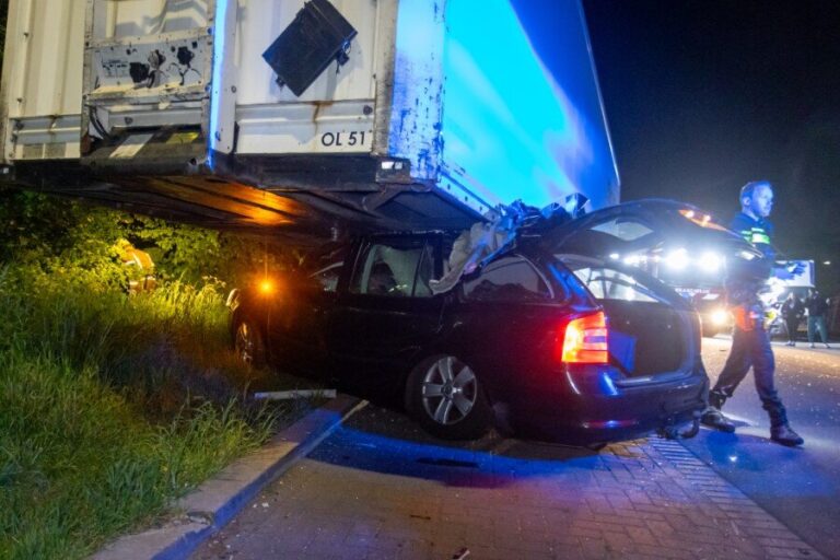 Auto klem onder vrachtwagentrailer
