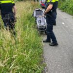 Lege kinderwagen bij sloot sportvelden
