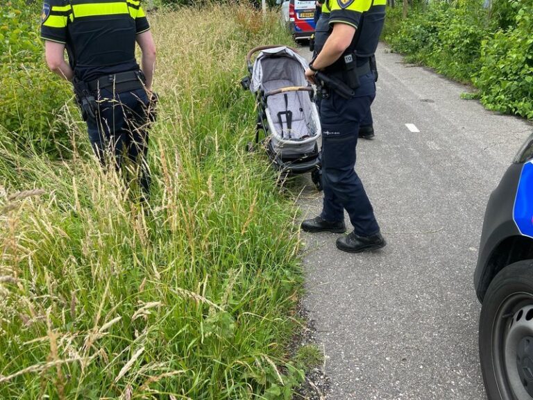 Lege kinderwagen bij sloot sportvelden